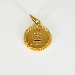 AUGIS - Médaille sentimentale en or jaune et rubis.
