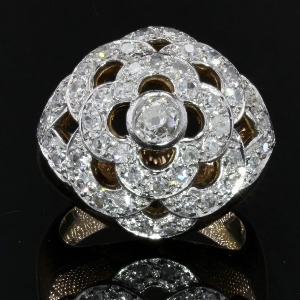Bague boule ajourée d'un décor de fleur et diamants