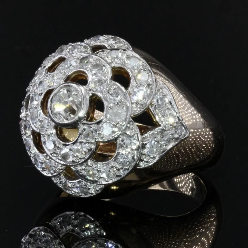 Bague boule ajourée d'un décor de fleur et diamants