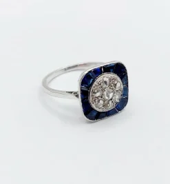 Bague cible art deco or blanc 18k et platine ornée de diamants entouré de saphirs calibrés synthétiques (circa 1930)