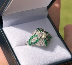 Bague de style Art Déco en platine avec diamants et émeraudes.