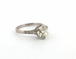 Bague en or blanc avec gros diamant central et diamants sur la tige