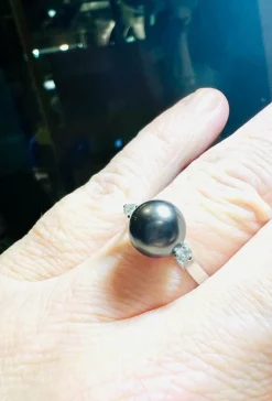 Bague en or blanc, perle de culture grise entourée de 2 diamants