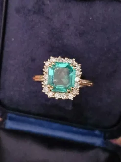 Bague en or jaune avec halo de diamants et émeraude colombienne