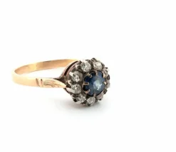 Bague en or jaune et argent avec saphir central et diamants environnants
