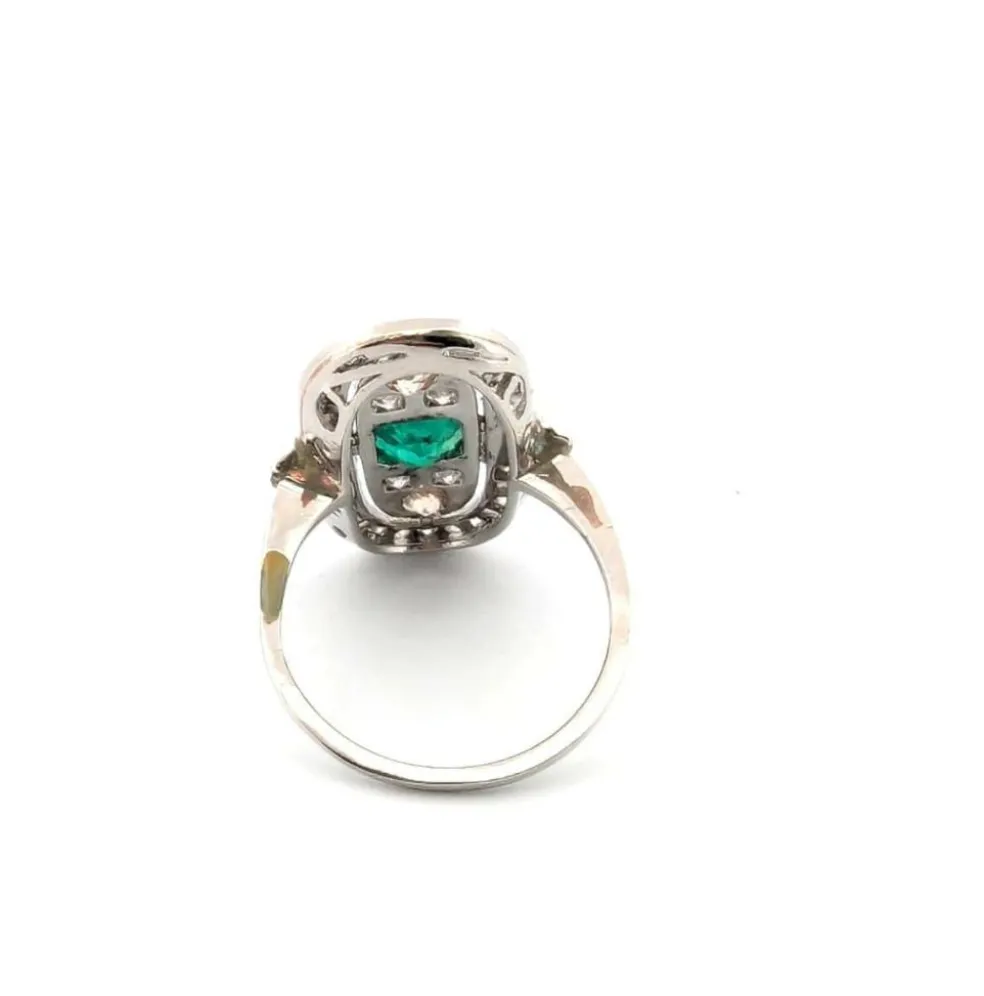 Bague en platine avec émeraude centrale et diamants environnants