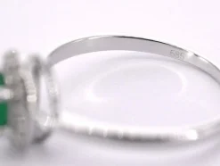 Bague entourage en or blanc avec diamants et émeraude