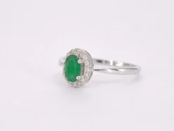 Bague entourage en or blanc avec diamants et émeraude