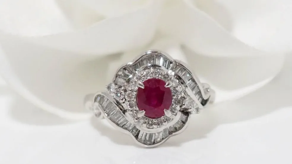 Bague entourage en platine, rubis ovale et diamants
