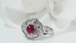 Bague entourage en platine, rubis ovale et diamants