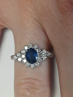 Bague marguerite en or blanc ornée d'un saphir