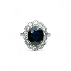 Bague marguerite en platine centrée d’un saphir entouré de diamants.