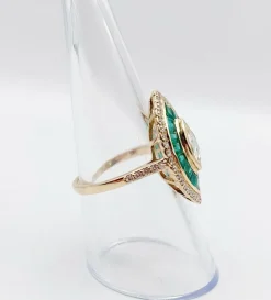 Bague marquise style art deco or jaune ornée de diamants entouré d'émeraude