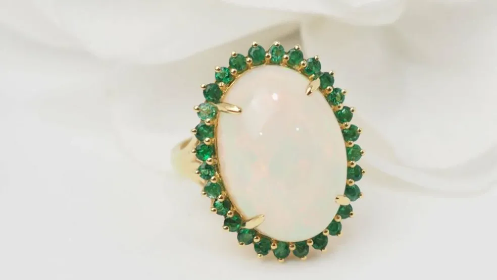 Bague ovale en or jaune, opale cabochon et émeraudes