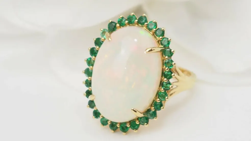 Bague ovale en or jaune, opale cabochon et émeraudes