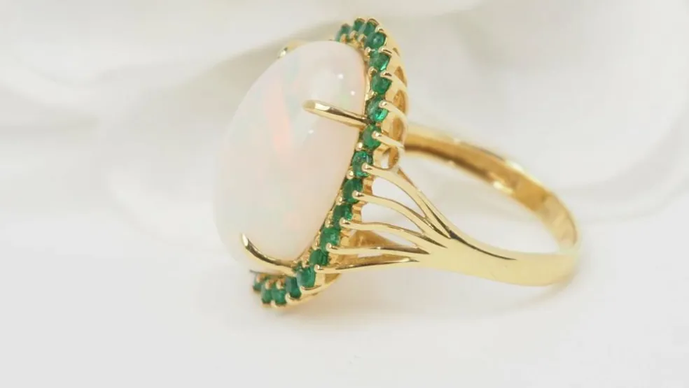 Bague ovale en or jaune, opale cabochon et émeraudes