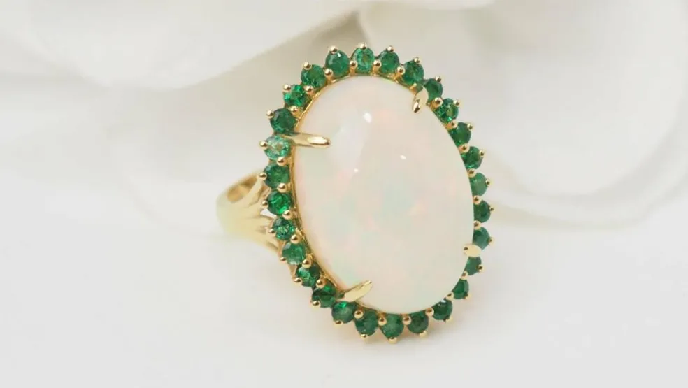 Bague ovale en or jaune, opale cabochon et émeraudes