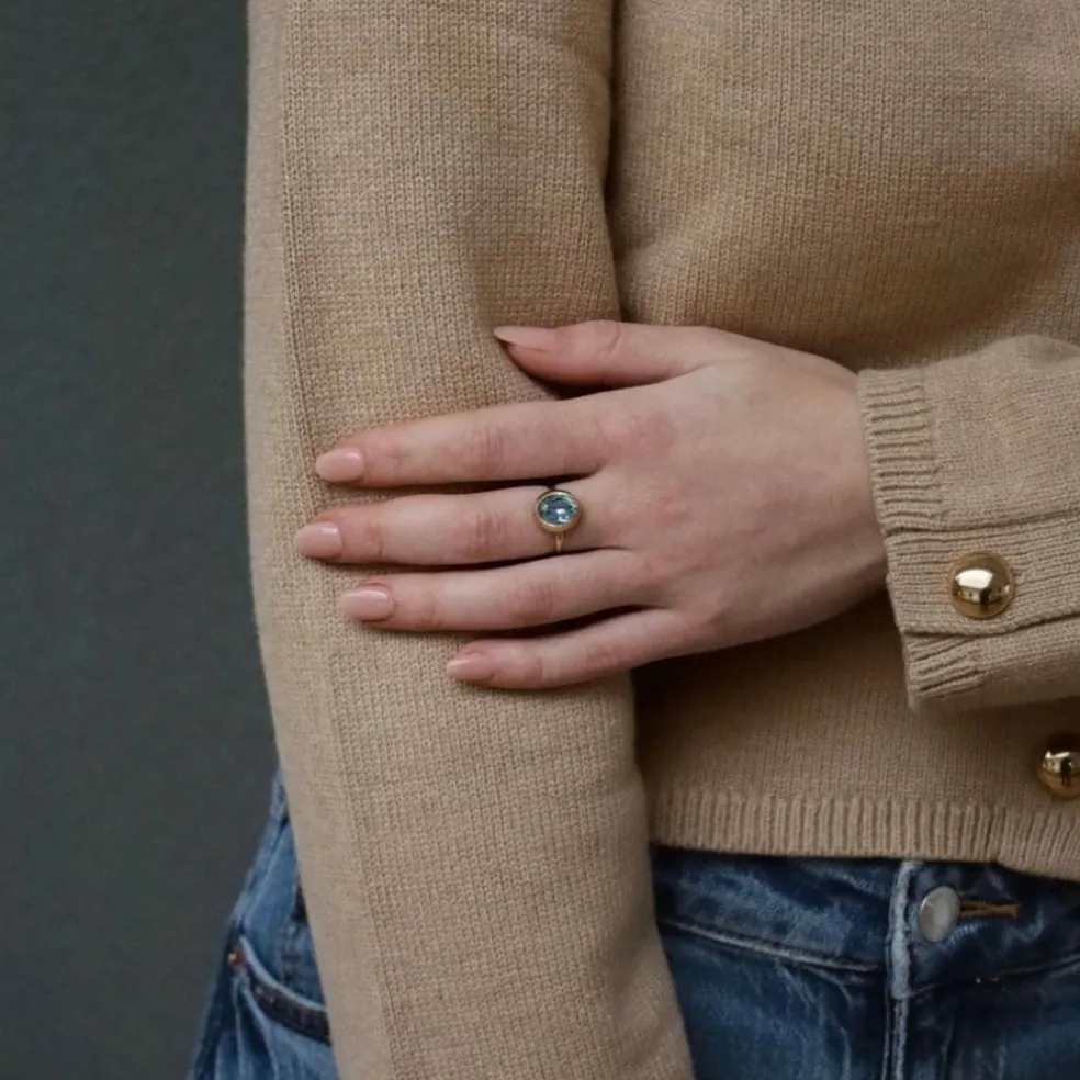 Bague solitaire en or rose avec topaze ovale bleue