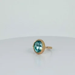 Bague solitaire en or rose avec topaze ovale bleue