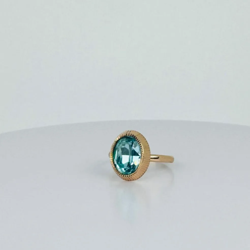 Bague solitaire en or rose avec topaze ovale bleue