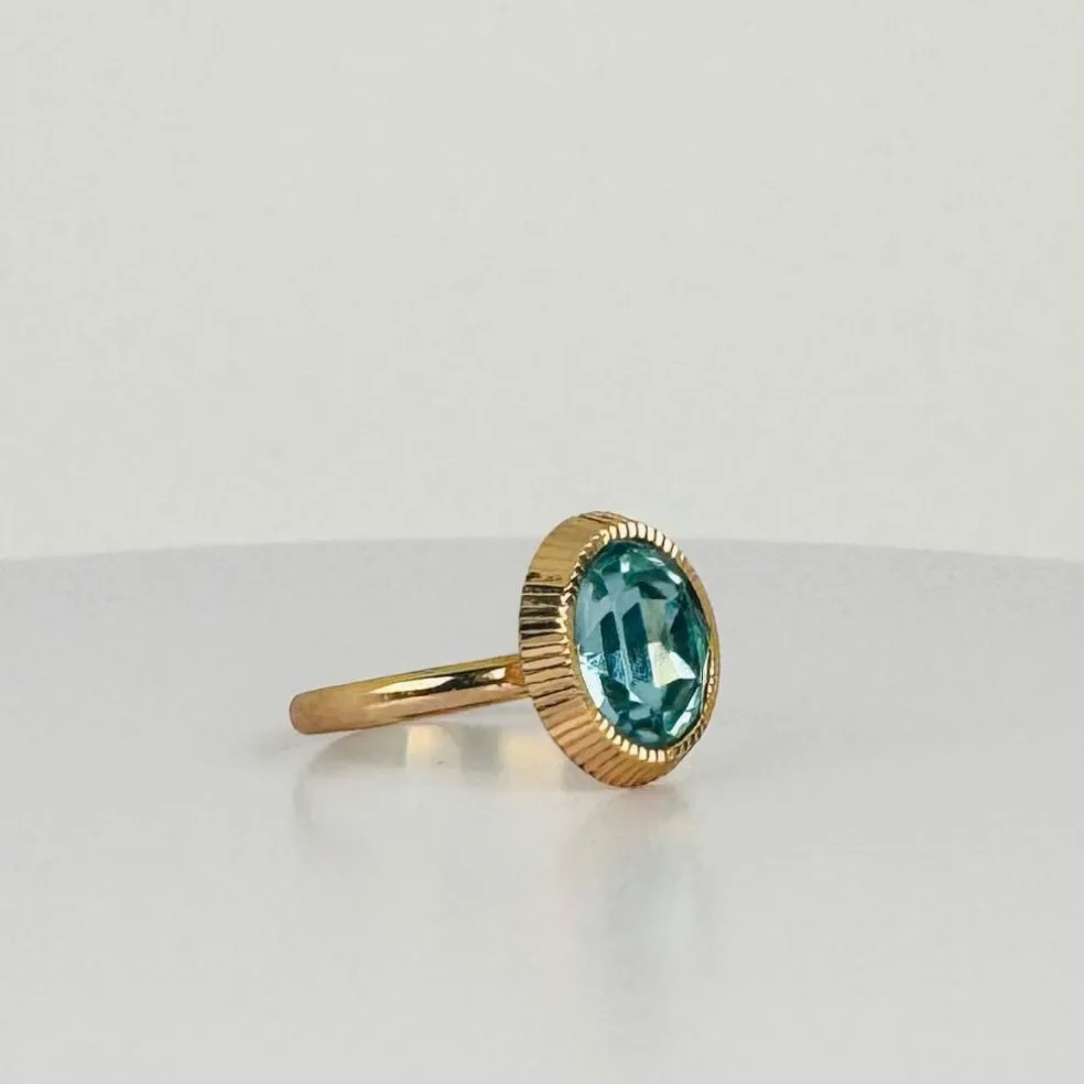Bague solitaire en or rose avec topaze ovale bleue