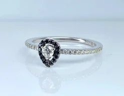 Bague solitaire or blanc, diamants blancs et diamants noirs.