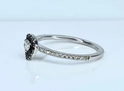 Bague solitaire or blanc, diamants blancs et diamants noirs.