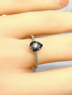 Bague solitaire or blanc, diamants blancs et diamants noirs.