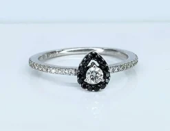 Bague solitaire or blanc, diamants blancs et diamants noirs.
