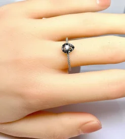Bague solitaire or blanc, diamants blancs et diamants noirs.