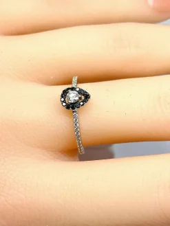 Bague solitaire or blanc, diamants blancs et diamants noirs.
