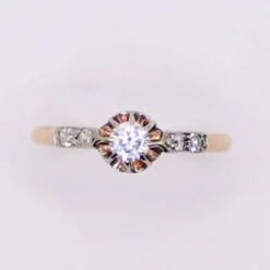 Bague solitaire épaulé de diamants serti sur or jaune et platine