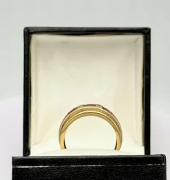 Bague style jarretière en or jaune sertie de rubis et diamant