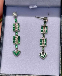 Boucles d'oreilles de style Art Déco en platine avec diamants et émeraudes.