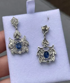 Boucles d'oreilles de style Art Déco en platine avec diamants et saphirs.