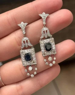 Boucles d'oreilles de style Art Déco en platine avec diamants et saphirs.