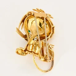 Broche Lion en or jaune et blanc, émeraudes, diamants et onyx