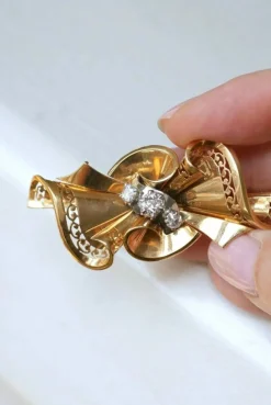 Broche noeud or rose, platine et diamants