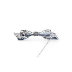 Broche nœud Art Déco platine, diamant, saphirs calibrés