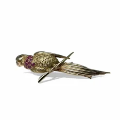 Broche oiseau en or jaune pavée de rubis.