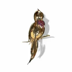Broche oiseau en or jaune pavée de rubis.