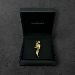 Broche oiseau en or jaune pavée de rubis.