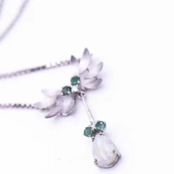 Collier en or blanc, opale, diamants et émeraude