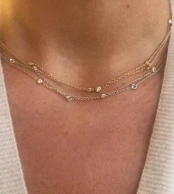 Collier or jaune intercalé de 9 diamants sur maille forçat en sertis clos.