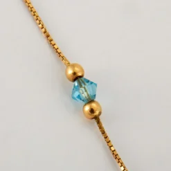 Pendentif croix topaze sur chaîne or jaune