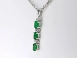 Pendentif en or blanc avec diamants et émeraude