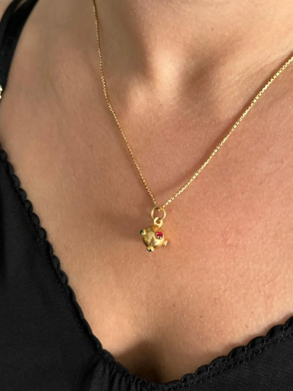 Pendentif en or forme boule avec rubis émeraude saphir