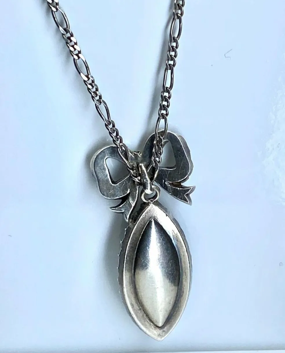 Pendentif et sa chaine en argent : enfant sur email et pierres blanches. Vers 1900