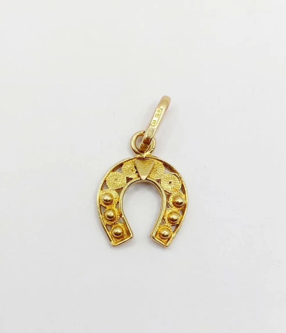 Pendentif vintage or jaune représentant un fer à cheval finement décoré