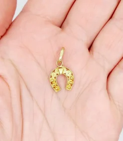 Pendentif vintage or jaune représentant un fer à cheval finement décoré